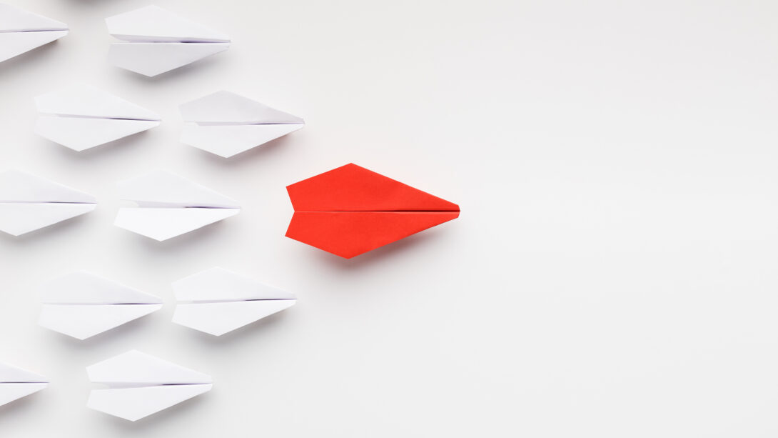 Focus Your culture - Opinion leadership concept. Red paper plane leading another ones, influencing the crowd, white background, top view with free space